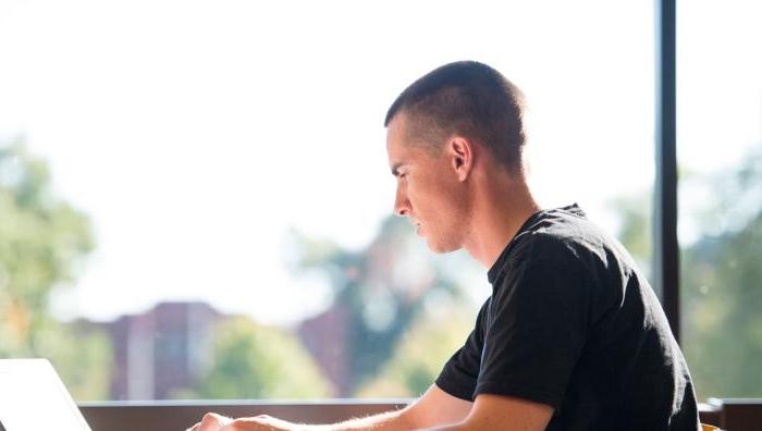 A student works on his laptop in the Library.