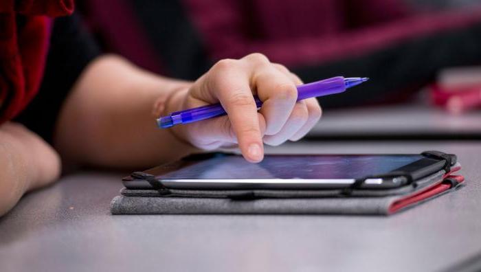 A close up of a student's hand using an iPad.